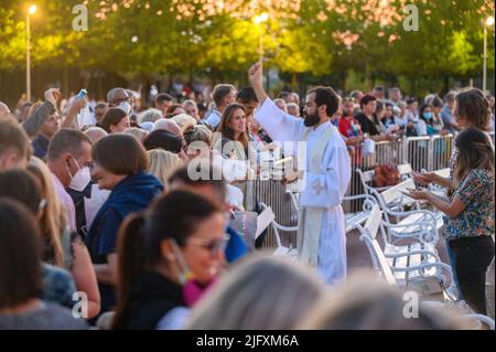 Un sacerdote benedice gli articoli religiosi dei fedeli dopo la Santa Messa serale a Medjugorje il 4 settembre 2021. Foto Stock