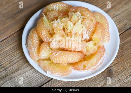 Frutta di pomelo su piatto bianco, pomelo fresco pelato frome pomelo albero , pommelo , pompelmo in estate frutta tropicale in thailandia Foto Stock