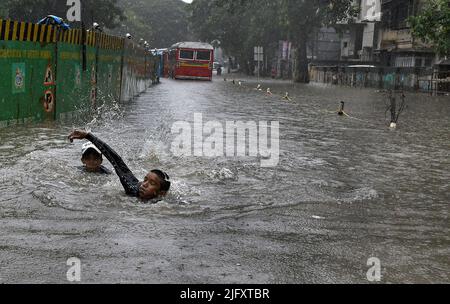 Mumbai, India. 05th luglio 2022. I ragazzi sono veduti nuotare nella strada allagata in mezzo alle forti piogge di Mumbai. Mumbai ha assistito a forti piogge a causa delle quali le strade sono state registrate nelle aree basse e il traffico è stato lento in movimento attraverso la città. Il Dipartimento meteorologico indiano (IMD) ha previsto piogge da moderate a pesanti nelle prossime 24 ore della città. Credit: SOPA Images Limited/Alamy Live News Foto Stock