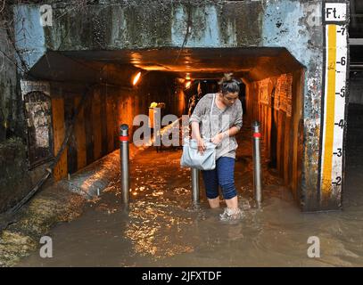 Mumbai, India. 05th luglio 2022. Una donna esce da una metropolitana allagata in mezzo alle forti piogge di Mumbai. Mumbai ha assistito a forti piogge a causa delle quali le strade sono state registrate nelle aree basse e il traffico è stato lento in movimento attraverso la città. Il Dipartimento meteorologico indiano (IMD) ha previsto piogge da moderate a pesanti nelle prossime 24 ore della città. Credit: SOPA Images Limited/Alamy Live News Foto Stock