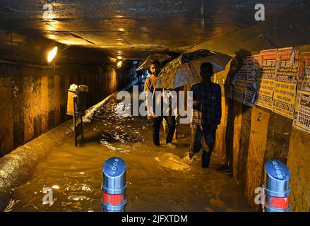 Mumbai, India. 05th luglio 2022. Le persone che trasportano gli ombrelloni camminano attraverso una metropolitana allagata in mezzo alle forti piogge di Mumbai. Mumbai ha assistito a forti piogge a causa delle quali le strade sono state registrate nelle aree basse e il traffico è stato lento in movimento attraverso la città. Il Dipartimento meteorologico indiano (IMD) ha previsto piogge da moderate a pesanti nelle prossime 24 ore della città. Credit: SOPA Images Limited/Alamy Live News Foto Stock