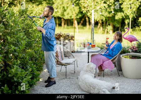 La giovane famiglia trascorre il tempo estivo nel cortile della propria casa di campagna Foto Stock