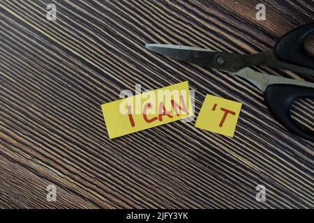 Concetto di taglio della parola in carta nota non posso leggere posso scrivere su note appiccicose isolate su tavola di legno. Foto Stock