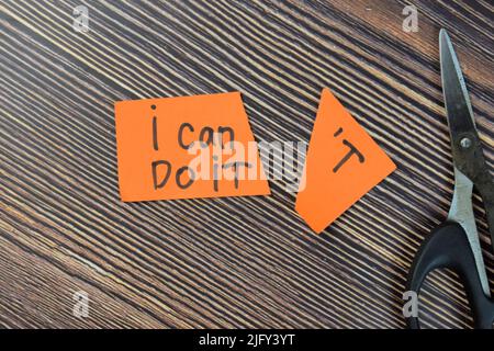 Concetto di taglio della parola in carta nota non posso farlo per leggere posso farlo scrivere su note adesive isolato su tavola di legno. Foto Stock