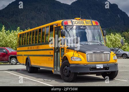 Scuola bus sul parcheggio su sfondo soleggiato. Bus scuola giallo. Foto di strada, nessuno, fuoco selettivo-Giugno 22,2022-Langley BC Canada Foto Stock