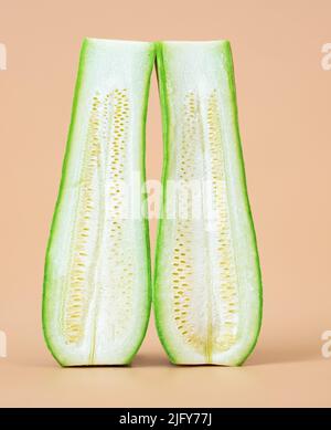 Due metà di una zucchina, o zucchina tagliata longitudinalmente al centro. Vegetale fresco o concetto di rapporto Foto Stock