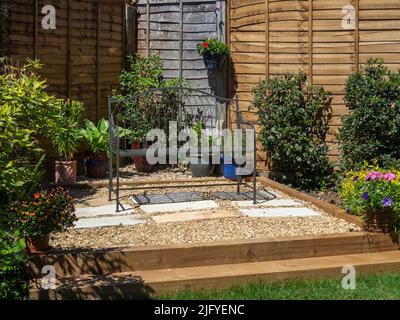 Area patio creata con traversine di legno e un'infilmazione di ghiaia, in un giardino suburbano, Northampton, Regno Unito Foto Stock