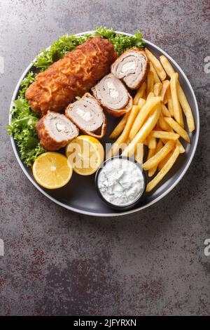 Caraffa Serba Karageorge Schnitzel servito con patatine fritte e salsa tartara in un piatto sul tavolo. Vista dall'alto verticale Foto Stock