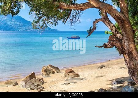 Barca ancorata al largo della spiaggia a Nosy Komba isola, Nord Ovest Madagascar, Oceano Indiano, Africa Foto Stock