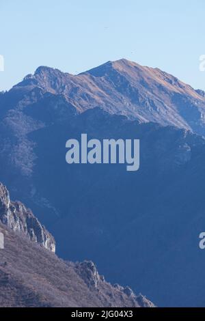 Le montagne tra la val camonica e la val seriana, vicino al lago d'iseo, durante l'ora d'oro di una giornata invernale vicino alla città di zone, Italia, febbraio 2022 Foto Stock