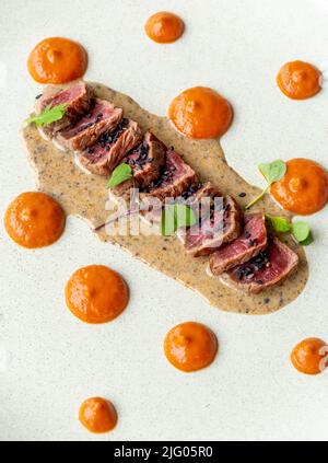 Tataki di manzo Angus con crema di harissa di rose e salsa al tartufo. Foto Stock