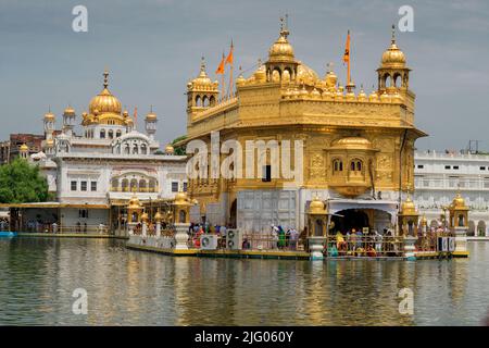 Amritsar ,8 ,Aprile :2014,riflessione del complesso del Tempio d'Oro con i devoti nel laghetto Sacro, Amritsar, Punjab, India Foto Stock