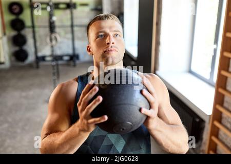 giovane con palla medica in palestra Foto Stock