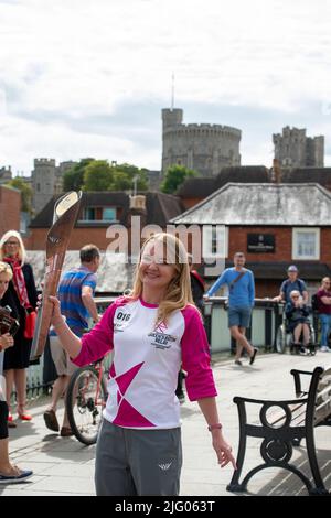 Eton, Windsor, Berkshire, Regno Unito. 6th luglio 2022. Baton Carrier Jemma Wood si erge sul Ponte di Windsor con vedute del Castello di Windsor. Jemma è stato nominato da PwC per portare il testimone. Jemma ha fibrosi cistica e ha trascorso 740 giorni della sua vita in ospedale, 530 giorni dedicati ai nebulizzatori/fisiologico e prende 720 compresse al mese. Nonostante ciò, Jemma ha raggiunto l'adesione onoraria alla squadra di ginnastica dell'Università di Londra e ha raccolto oltre £300.000 persone per il Cystic Fibrosis Trust. Credit: Maureen McLean/Alamy Live News Foto Stock