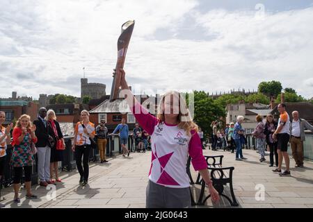 Eton, Windsor, Berkshire, Regno Unito. 6th luglio 2022. Baton Carrier Jemma Wood si erge sul Ponte di Windsor con vedute del Castello di Windsor. Jemma è stato nominato da PwC per portare il testimone. Jemma ha fibrosi cistica e ha trascorso 740 giorni della sua vita in ospedale, 530 giorni dedicati ai nebulizzatori/fisiologico e prende 720 compresse al mese. Nonostante ciò, Jemma ha raggiunto l'adesione onoraria alla squadra di ginnastica dell'Università di Londra e ha raccolto oltre £300.000 persone per il Cystic Fibrosis Trust. Credit: Maureen McLean/Alamy Live News Foto Stock