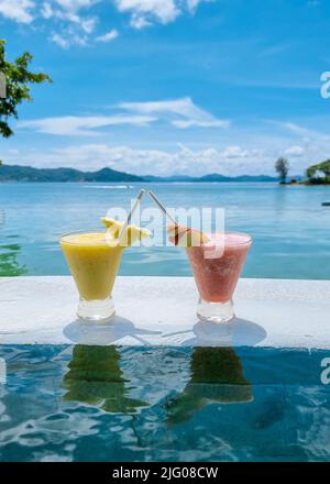 cocktail sul bordo di una piscina a sfioro di un hotel di lusso. cocktail di frutta colorati Foto Stock