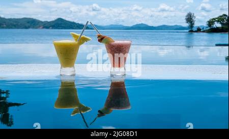 cocktail sul bordo di una piscina a sfioro di un hotel di lusso. cocktail di frutta colorati Foto Stock