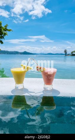 cocktail sul bordo di una piscina a sfioro di un hotel di lusso. cocktail di frutta colorati Foto Stock