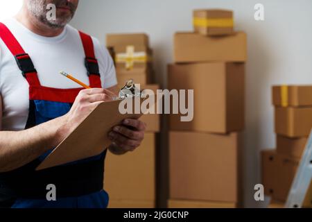 L'uomo di mezza età si mover in uniforme facendo note sugli appunti Foto Stock