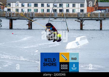 Dundee, Tayside, Scozia, Regno Unito. 6th luglio 2022. UK Meteo: Una giornata nuvolosa con venti freddi ad ovest, temperature che raggiungono i 18°C nella Scozia nord-orientale. I wakeboarder del Wild Shore possono praticare sport acquatici e godersi una giornata di wakeboarding su un treno al West Victoria Dock di Dundee's City Quay. Credit: Dundee Photographics/Alamy Live News Foto Stock