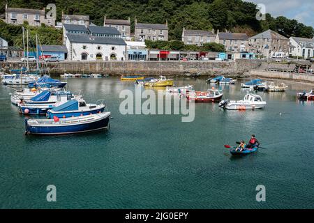 I turisti si divertiranno in kayak nel porto interno di Porthleven, Cornovaglia Foto Stock