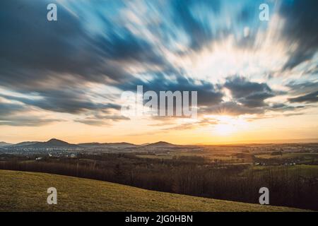 Bellissimo tramonto con nuvole sfocate sulla valle di Beskydy vicino a Kopřivnice, nella Repubblica Ceca, nel centro d'Europa. Luce rossa-gialla nella sk Foto Stock