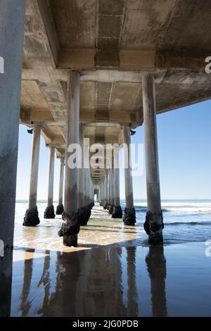 Vista unica sotto il Molo di Huntington Beach, struttura in legno e mare a Huntington Beach, California USA Foto Stock