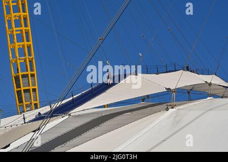 Londra, Inghilterra - Giugno 2022: Persona che sale sul tetto dell'arena O2 a Londra, con altre persone al top. Foto Stock