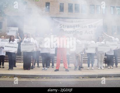 Londra, Inghilterra, Regno Unito. 6th luglio 2022. I manifestanti si trovano dietro una 'cortina di mokescreening'. Gli attivisti si sono riuniti al di fuori della corte della corona di Southwark per protestare contro la caccia alle volpi e hanno chiesto che la legge di caccia sia rafforzata quando inizia l'udienza di appello per Mark Hankinson. Hankinson è stato giudicato colpevole di aver incoraggiato o aiutato altri ad usare ''caccia al sentiero'' come copertura per inseguire e uccidere volpi illegalmente. (Credit Image: © Vuk Valcic/ZUMA Press Wire) Foto Stock