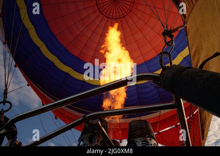 Un pallone ad aria calda. Fiamme arancioni sparano nella busta del palloncino per riempirla di aria calda. Foto Stock