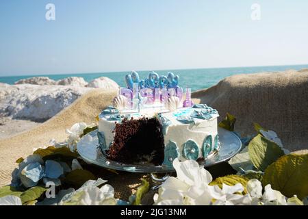 L'immagine della torta di compleanno mangiata a metà ha mangiato la spiaggia. Foto Stock