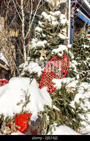 All'esterno albero di Natale decorato con racchette da neve e una scatola regalo. Foto Stock