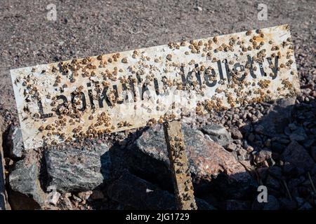 Läpikulku kielletty. Seashell segno di metallo coperto salvato dal mare nel distretto di Munkkiniemi di Helsinki, Finlandia. Foto Stock