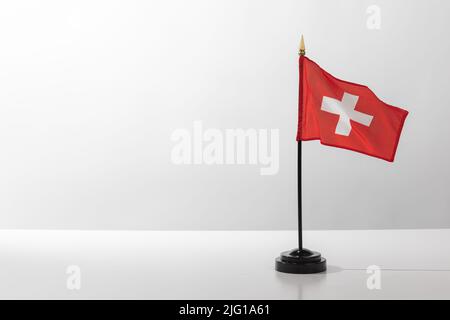 Flying Country Flag Svizzera isolato su un tavolo bianco con sfondo grigio Foto Stock