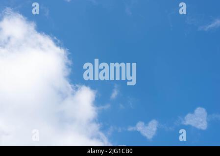 nuvole in forma di cuori su un cielo blu, spazio per il testo. Foto di alta qualità Foto Stock