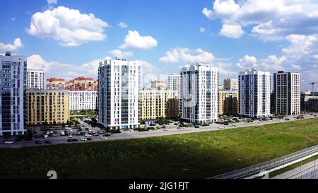 Vista aerea di una moderna strada cittadina in una giornata estiva di sole. Riprese in stock. Edifici di una nuova e moderna zona notte su sfondo blu cielo nuvoloso Foto Stock