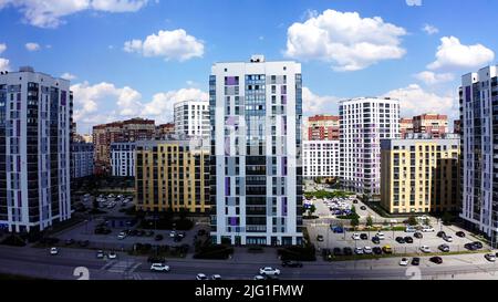 Vista aerea di una moderna strada cittadina in una giornata estiva di sole. Riprese in stock. Edifici di una nuova e moderna zona notte su sfondo blu cielo nuvoloso Foto Stock