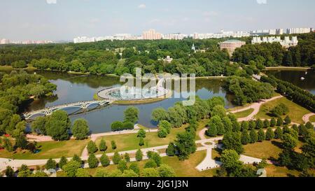 Vista aerea di un grande stagno, cespugli e alberi in un parco cittadino. Creativa. Giorno d'estate in un parco su sfondo cielo blu Foto Stock