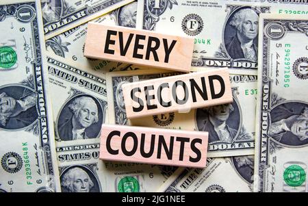 Ogni secondo conta il simbolo. Parole di concetto ogni secondo conta su blocchi di legno su uno sfondo bello dalle fatture del dollaro. Business, motivazionale e. Foto Stock