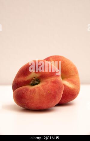 Pesche di ciambella davanti ad uno sfondo bianco giallastro Foto Stock