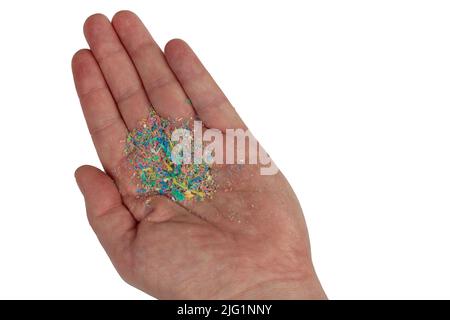 Problema ambientale, contaminazione dell'ambiente con microplastica. Frammenti di plastica sulla mano Foto Stock