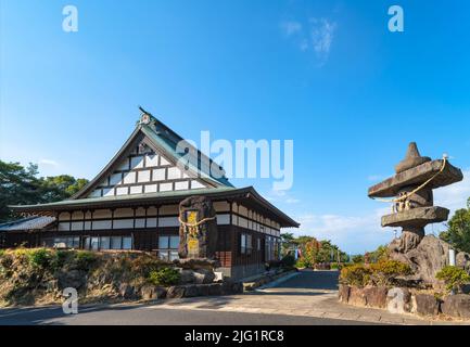 kyushu, giappone - dicembre 09 2021: Tempio buddista Jôjuin adornato con una stele di pietra e una lanterna circondata da corde di shimenawa vicino al Funakoshi Foto Stock