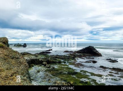 Una spiaggia rocciosa con ormeggio su Islanda in forti venti con surf potente Foto Stock
