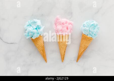 Tre coni di cialde riempiti di caramelle di cotone, su uno sfondo leggero. Foto Stock