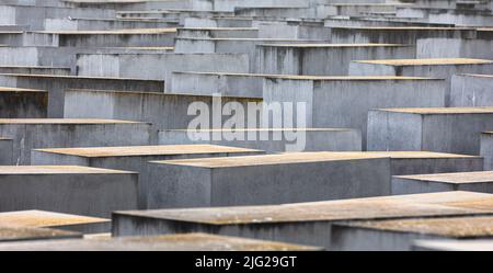 Una vista di lastre di cemento o 'tele' parte del Memoriale degli ebrei assassinati d'Europa o 'Memoriale dell'Olocausto' situato a sud della porta di Brandeburgo. Il Memoriale agli ebrei assassinati d'Europa, noto anche come Memoriale dell'Olocausto, è un memoriale a Berlino per le vittime ebraiche dell'Olocausto, progettato dall'architetto Peter Eisenman e Buro Happold. Si compone di un sito di 19.000 metri quadrati coperto con 2.711 lastre di cemento o 'telae', disposti in un disegno a griglia su un campo inclinato. Essi sono organizzati in righe, 54 di loro andando northñsouth, e 87 andando eastñwest ad angolo retto ma regolato scivolando Foto Stock