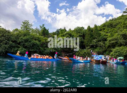 LIJIANG, CINA - 7 LUGLIO 2022 - Foto aerea scattata il 7 luglio 2022 mostra i turisti che visitano l'isola di Liwubi nel lago di Lugu a Lijiang, provincia di Yunnan, Chi Foto Stock