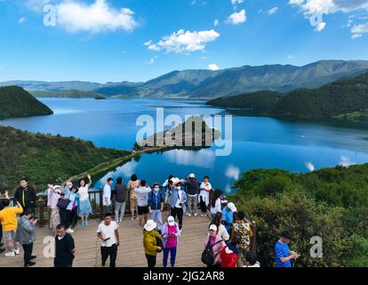 LIJIANG, CINA - 7 LUGLIO 2022 - Foto aerea scattata il 7 luglio 2022 mostra i turisti che visitano l'isola di Lige nel lago di Lugu a Lijiang, provincia di Yunnan, Cina Foto Stock