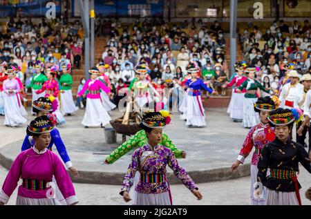 LIJIANG, CINA - 7 LUGLIO 2022 - i residenti di Mosuo in costumi etnici ballano per i turisti durante una festa di falò al lago di Lugu a Lijiang, provincia di Yunnan, Foto Stock