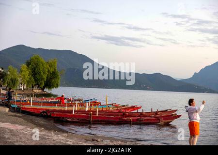 LIJIANG, CINA - 7 LUGLIO 2022 - i turisti scattano foto accanto al lago di Lugu a Lijiang, provincia di Yunnan, Cina, 7 luglio 2022. Lago Lugu, conosciuto come la 'Perla Foto Stock