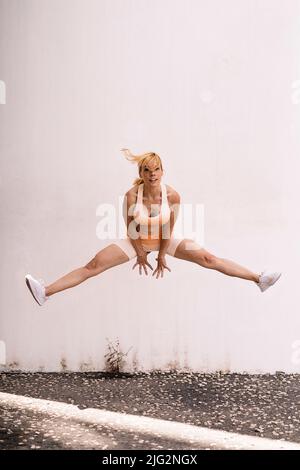 Atleta femminile isolata che salta all'aperto Foto Stock